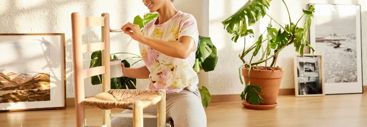 Person streicht einen Stuhl